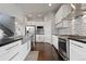 Bright kitchen boasts stainless steel appliances, white cabinets, and a stylish mosaic tile backsplash at 1813 W 67Th Ave, Denver, CO 80221