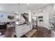 Modern kitchen with an island featuring seating, stainless steel appliances, and open floor plan to the living room at 1813 W 67Th Ave, Denver, CO 80221