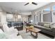 Modern open floor plan: living room, dining area, and kitchen featuring hardwood floors and ample natural light at 1813 W 67Th Ave, Denver, CO 80221