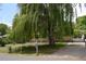 Charming brick home with a large willow tree, green lawn, and white mailbox at 2885 Quay St, Wheat Ridge, CO 80033