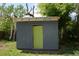 Exterior view of a backyard shed featuring painted siding, a contrasting bright green door, and an awning at 2885 Quay St, Wheat Ridge, CO 80033