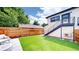 Backyard features a well-maintained lawn, new fence, and upper deck access via metal stairwell at 2405 S Franklin, Denver, CO 80210