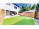 Backyard lawn, new fence, and patio area with modern furnishings and glass doors to interior at 2405 S Franklin, Denver, CO 80210