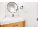 Stylish half bathroom featuring a round mirror, quartz countertop, and modern fixtures at 2405 S Franklin, Denver, CO 80210