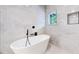 Bright, modern bathroom features a stand alone tub and floor-to-ceiling marble tile at 2405 S Franklin, Denver, CO 80210