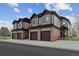 Three-unit townhome building with attached garages and brick accents at 10810 W 63Rd Ave # C, Arvada, CO 80004