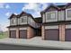 Three-unit townhome building with attached garages and brick accents at 10810 W 63Rd Ave # C, Arvada, CO 80004