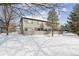 Rear view of the house with a snow covered yard at 10810 W 63Rd Ave # C, Arvada, CO 80004