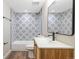 Updated bathroom features tile shower, modern vanity and a framed mirror at 15 Hazel Ct, Denver, CO 80219