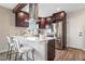 Modern kitchen features stainless steel appliances, dark cabinetry, and a bright white countertop with breakfast bar seating at 15 Hazel Ct, Denver, CO 80219