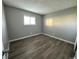 This bedroom has gray walls, wood-look floors, and natural light from the window at 10211 Ura Ln # 7-108, Thornton, CO 80260