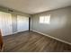 This bedroom features wood-look floors, gray walls, and a window with a double closet at 10211 Ura Ln # 7-108, Thornton, CO 80260