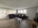 Living room featuring hardwood floors, two couches, a coffee table, and a television at 10211 Ura Ln # 7-108, Thornton, CO 80260