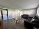 Living room featuring hardwood floors, two couches, a coffee table, washer and dryer, and door at 10211 Ura Ln # 7-108, Thornton, CO 80260