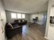 Living room featuring hardwood floors, two couches, a coffee table, and a television at 10211 Ura Ln # 7-108, Thornton, CO 80260