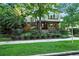 Beautifully landscaped home with mature trees, a manicured lawn, and a wrought iron fence at 325 S High St, Denver, CO 80209