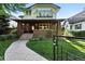 Inviting two-story home with a brick facade, covered front porch, manicured lawn, and sidewalk at 325 S High St, Denver, CO 80209