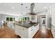 Kitchen with island cooktop, stainless steel vent hood, eat in counter and living room at 325 S High St, Denver, CO 80209
