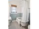 Quaint bathroom showcases a clawfoot tub and charming black and white tile flooring at 2210 E Mississippi Ave # 3, Denver, CO 80210