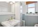 Bright bathroom with pedestal sink and window for natural light at 2210 E Mississippi Ave # 3, Denver, CO 80210