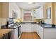 Well-appointed kitchen with white cabinets, black countertops, and modern appliances at 2210 E Mississippi Ave # 3, Denver, CO 80210