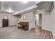 A large basement area features a carpeted floor and a classic wooden piano and a hallway leading to other rooms at 14713 Josephine St, Thornton, CO 80602