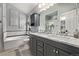 Modern bathroom with double vanity, tub, and decorative backsplash at 14713 Josephine St, Thornton, CO 80602
