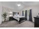 This primary bedroom features gray carpet, dark wood furniture, natural lighting, and a modern ceiling fan at 14713 Josephine St, Thornton, CO 80602
