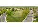 Aerial view of community open space featuring lush green grass and mature trees; recreational space for residents at 14713 Josephine St, Thornton, CO 80602