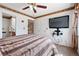 Comfortable bedroom with ensuite bathroom, mounted TV, ceiling fan, and a calming color palette at 4056 Perth St, Denver, CO 80249