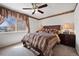 Bedroom featuring a luxurious bed, a ceiling fan, and large window allowing natural light into the room at 4056 Perth St, Denver, CO 80249
