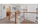 Well-lit upstairs hallway featuring white walls and warm wood bannister, leading to bedrooms and bathrooms at 4056 Perth St, Denver, CO 80249