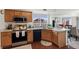 Charming kitchen with stainless steel appliances, wooden cabinetry, and a bar counter looking to dining room at 4056 Perth St, Denver, CO 80249