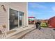 Sliding door to outdoor patio with barbecue grill and seating area, surrounded by gravel at 4056 Perth St, Denver, CO 80249