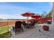 Outdoor patio with furniture, BBQ, and a red fence overlooking an open field at 4056 Perth St, Denver, CO 80249