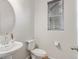 Clean half-bathroom with a pedestal sink, toilet, and window with blinds at 1918 W 165Th Way, Broomfield, CO 80023