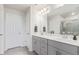 Bathroom featuring a double vanity with gray cabinets, a large mirror, and modern fixtures at 1918 W 165Th Way, Broomfield, CO 80023
