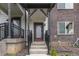 Inviting townhouse entrance featuring a maroon door, black railings, and stone landscaping at 1918 W 165Th Way, Broomfield, CO 80023