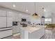 Open-concept kitchen featuring an island with quartz countertops and stainless steel appliances flowing into the living area at 1918 W 165Th Way, Broomfield, CO 80023