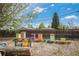 Backyard featuring colorful beehives behind a wooden fence, adding charm to the outdoor space at 6260 Lamar St, Arvada, CO 80003