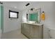 Bathroom featuring a dual sink vanity, modern light fixtures and a window, offering functionality and style at 6260 Lamar St, Arvada, CO 80003