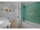 Bright bathroom features a white vanity, tub with unique tile surround and fun mythological art prints at 6260 Lamar St, Arvada, CO 80003