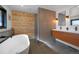 Modern bathroom with a freestanding tub, a wood accent wall and dual vanity, creating a spa-like retreat at 6260 Lamar St, Arvada, CO 80003