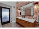 Stylish bathroom showcasing a wood vanity, patterned wallpaper, and contemporary fixtures at 6260 Lamar St, Arvada, CO 80003