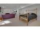 Basement bedroom featuring a comfortable bed, sitting area, stone fireplace and ample natural light at 6260 Lamar St, Arvada, CO 80003