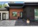 Modern home featuring wood and black exterior accents and stylish front entrance at 6260 Lamar St, Arvada, CO 80003
