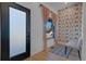 Bright foyer featuring wallpaper, light wood flooring, and a frosted glass door at 6260 Lamar St, Arvada, CO 80003