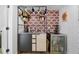 Compact kitchenette featuring a metal countertop, black cabinetry, floating shelves, and a mini fridge at 6260 Lamar St, Arvada, CO 80003