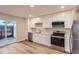 Modern kitchen design with white cabinets, wood floors, and access to outdoor patio at 1811 S Quebec Way # 31, Denver, CO 80231
