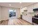 Well-lit kitchen featuring white cabinets, stainless steel appliances, and sliding glass doors to the patio at 1811 S Quebec Way # 31, Denver, CO 80231